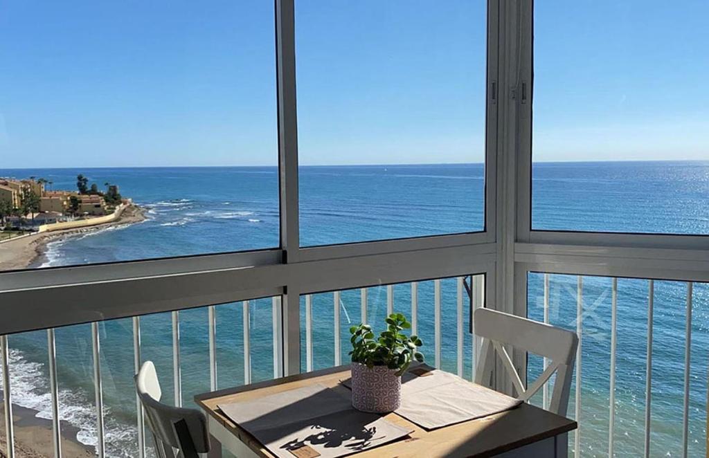 una mesa y sillas con vistas al océano en Estudio Edificio Almirante en Mijas Costa