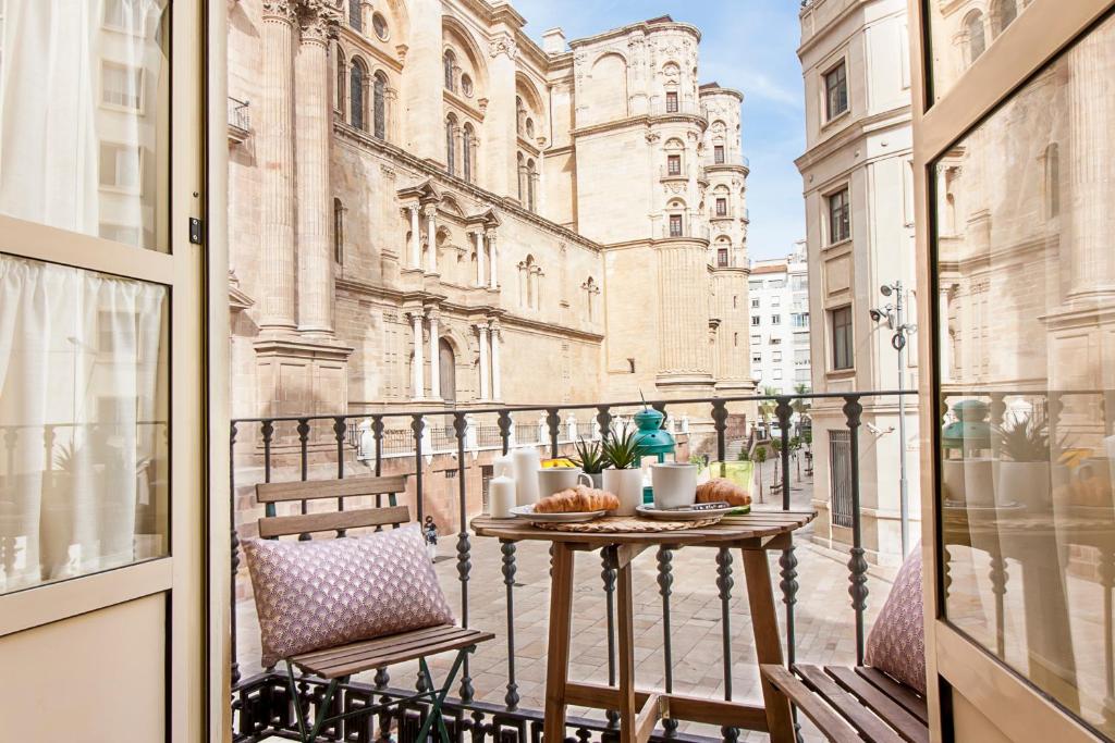 a balcony with a table and chairs on a balcony at Malaga Center Flat Cathedral in Málaga