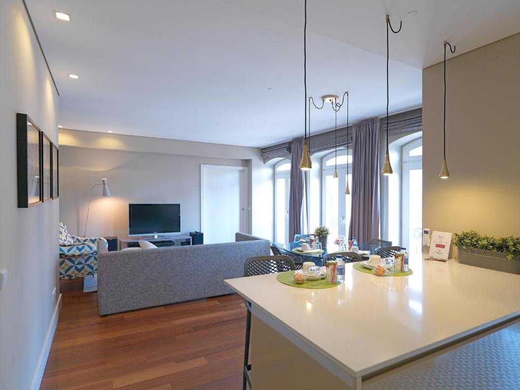 a kitchen and living room with a table and a couch at FLH New Oporto Apartments - São Bento in Porto