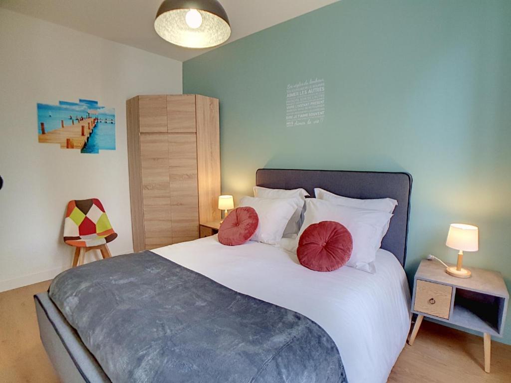 1 dormitorio con 1 cama con 2 almohadas rojas en Stop Chez M Select Street # Qualité # Confort # Simplicité, en Saint-Fons