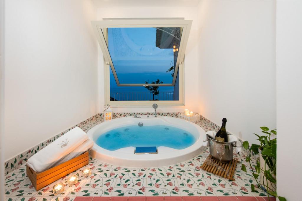 a bath tub in a bathroom with a window at Grand Hotel Tritone in Praiano