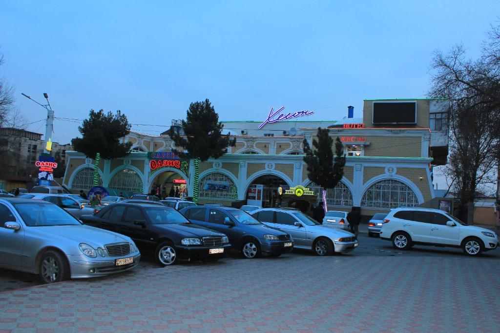 un grupo de coches estacionados frente a un edificio en Хотел Хесон en Khujand