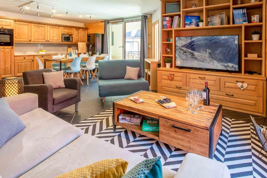 a living room with a television and a table at Le Paradis 25 Apartment - Chamonix All Year in Chamonix-Mont-Blanc