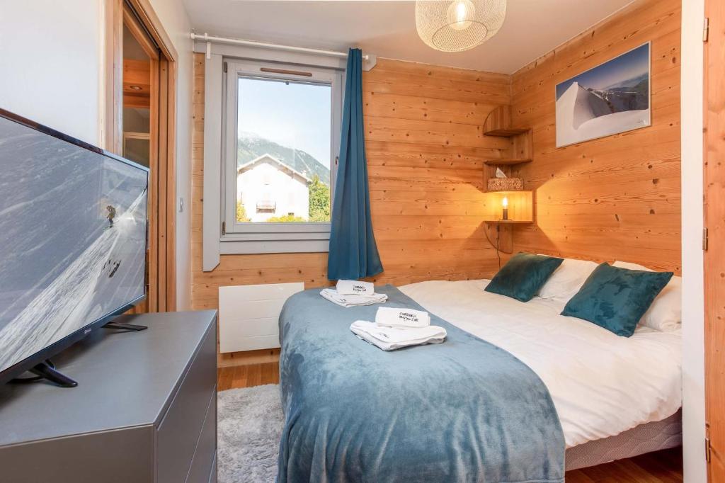 a bedroom with a bed and a flat screen tv at Le Paradis 25 Apartment - Chamonix All Year in Chamonix