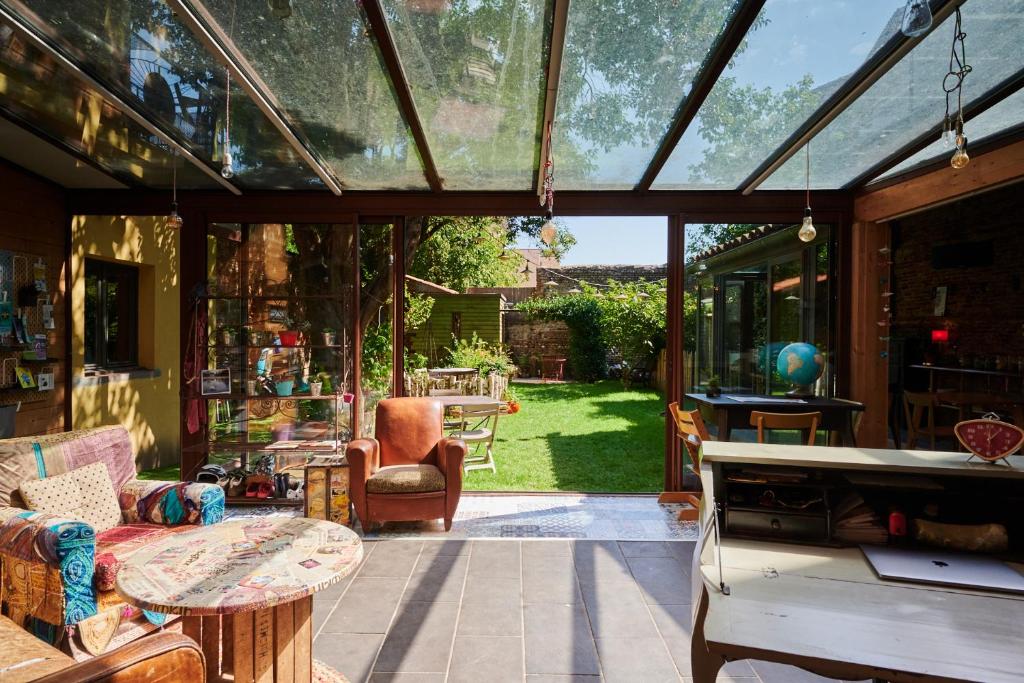 une véranda avec une porte en verre, une table et des chaises dans l'établissement Maison Anjali, à Toulouse