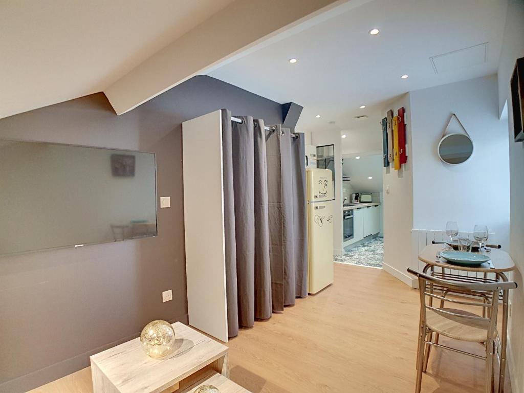 a living room with a table and a kitchen at Stop Chez M Select Sense # Qualité # Confort # Simplicité in Saint-Fons