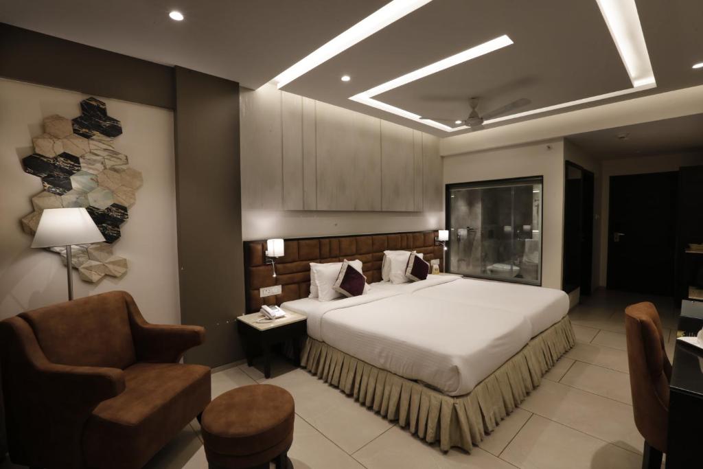 瓦斯科达伽马The Flora Grand, Vasco, Goa的一间带床和椅子的酒店房间