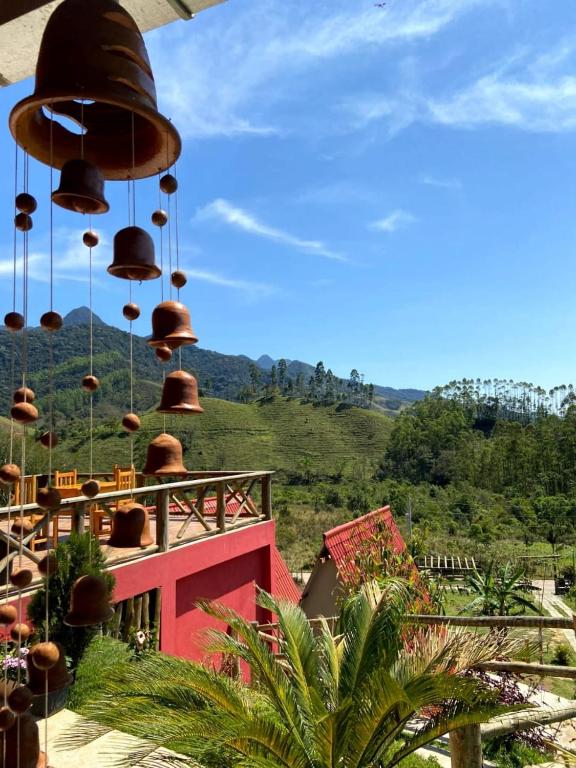 a bunch of bells hanging from a building at POUSADA PATRIMÔNIO DOS SONHOS in PatrimÃ´nio da Penha