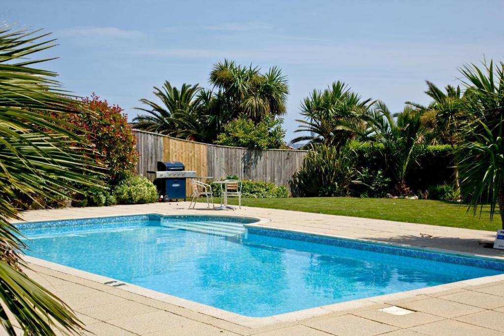 a small swimming pool in a yard with a fence at 3 Goodrington Lodge, Paignton in Paignton
