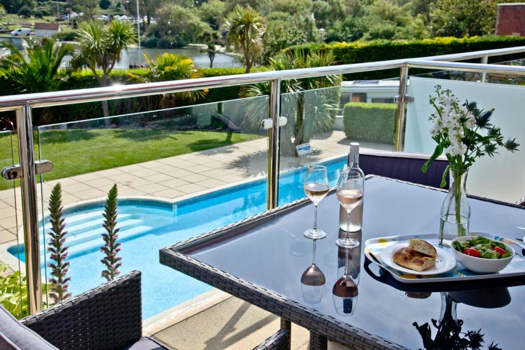a table with a plate of food and wine glasses at 3 Goodrington Lodge, Paignton in Paignton