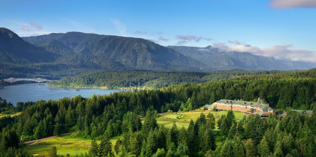 a house on a hill with a lake and mountains at Skamania Lodge in Stevenson