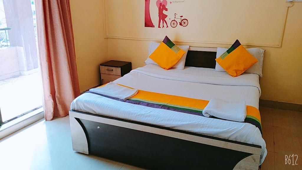 Dormitorio pequeño con cama con almohadas coloridas en Coronet Luxurious Apartment en Pune