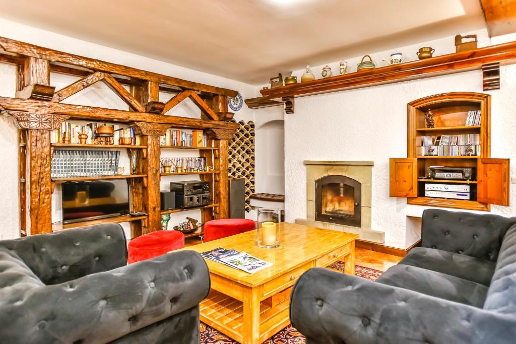 een woonkamer met een tafel en stoelen en een open haard bij Luxury town house in Arbós
