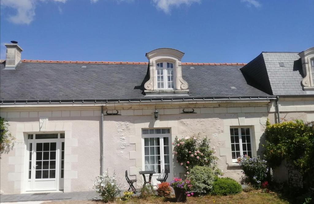 a white house with a gray roof and windows at Le clos des augers, chambres d'hôtes et roulotte in Azay-sur-Cher