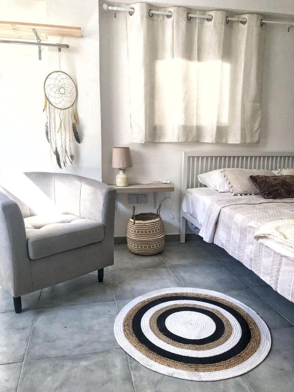 a bedroom with a bed and a chair and a rug at Katsikantaris Homes in Paphos