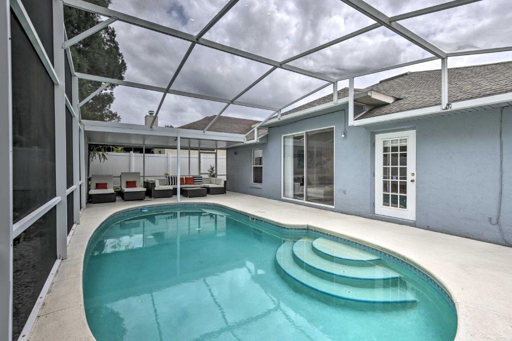 a swimming pool in a house with a glass ceiling at Apopka Single-Story Home with Private Lanai and Pool! in Orlando
