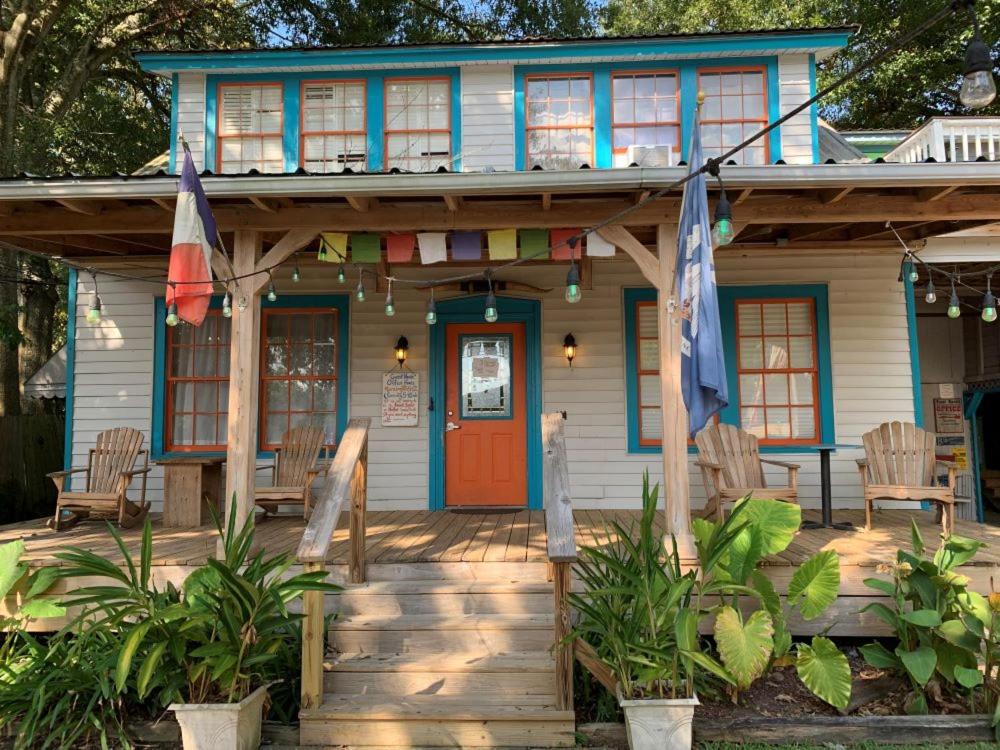 uma casa azul com uma porta vermelha e cadeiras em Blue Moon Guest House em Lafayette
