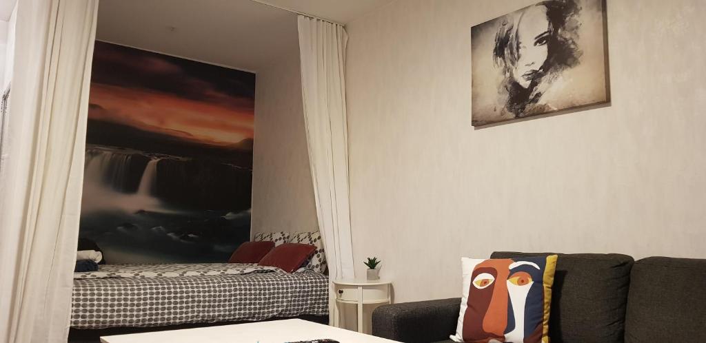 uma sala de estar com um sofá e um espelho em Studio near City - Puinnintie em Pori