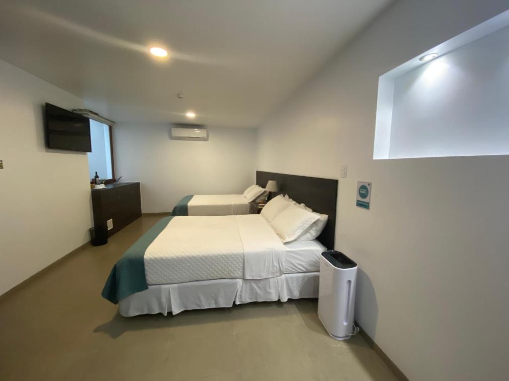 Postel nebo postele na pokoji v ubytování Galapagos Sunset Hotel