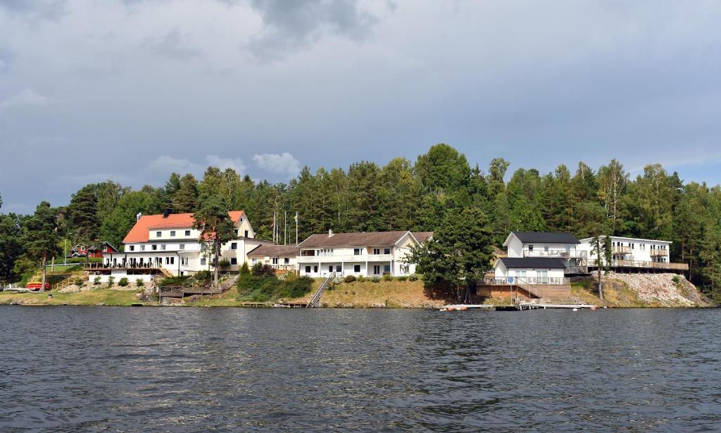 un groupe de maisons sur la rive d'un lac dans l'établissement Håveruds hotell och konferens, à Håverud