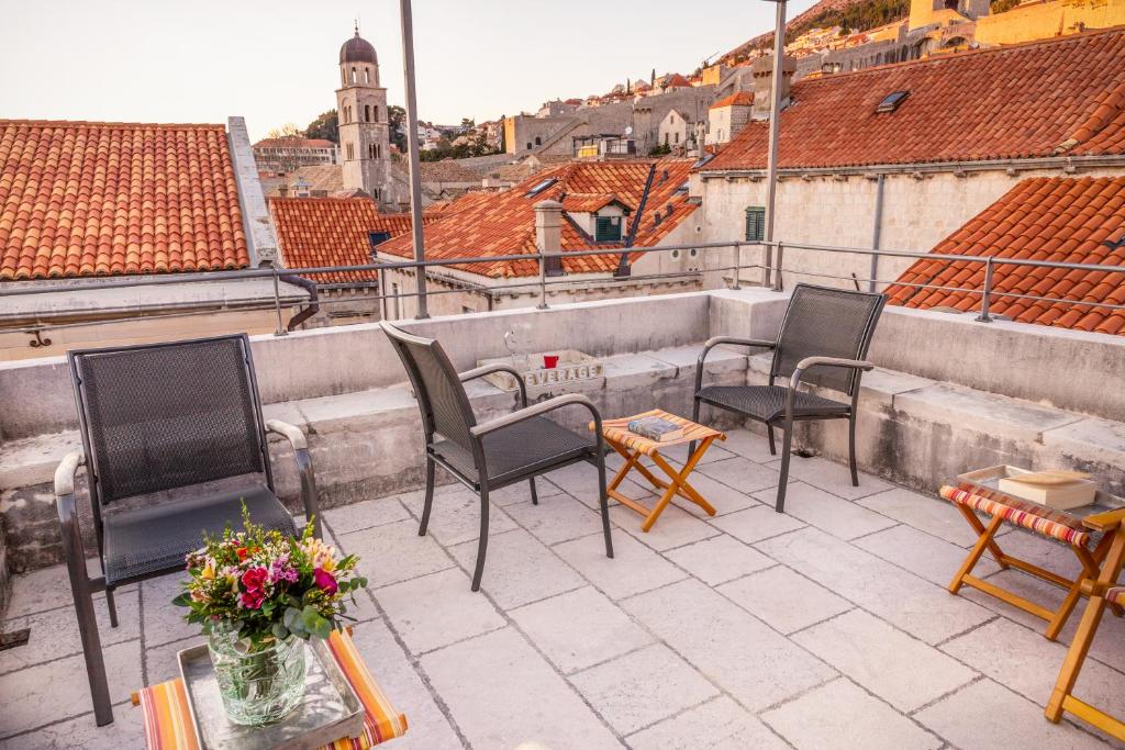 a patio area with chairs, tables, chairs, and umbrellas at Dubrovnik Luxury Apartments in Dubrovnik