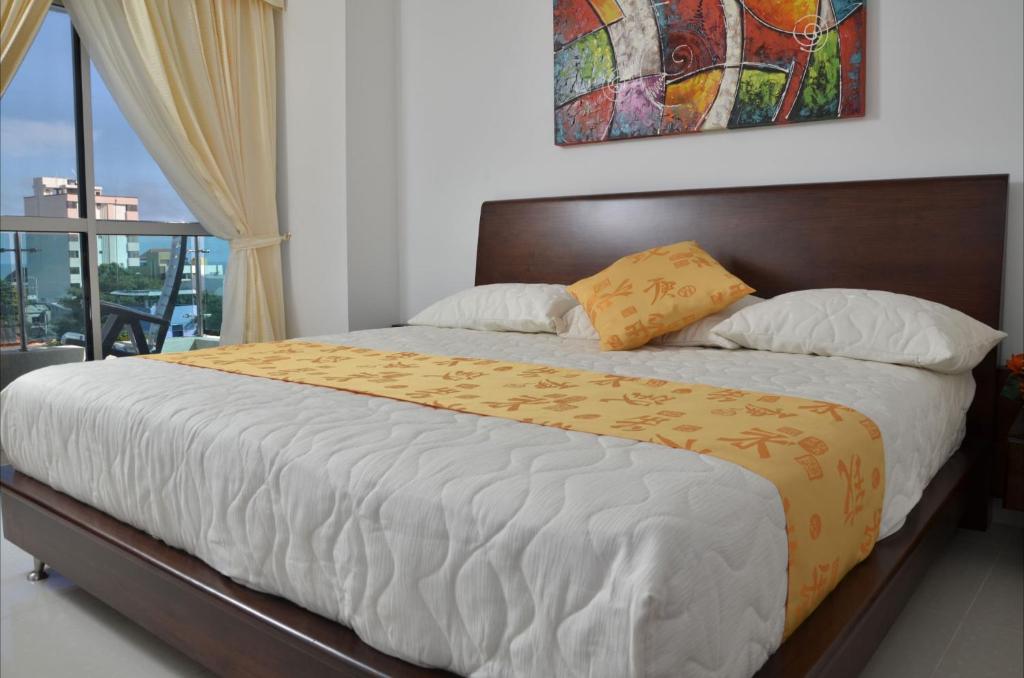 a bedroom with a large bed with a window at Hotel Miraflores RB in Ríohacha