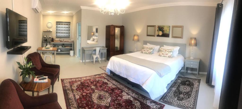 a bedroom with a bed and a living room at Steenkoppies Estate semi self catering unit 2 in Magaliesburg