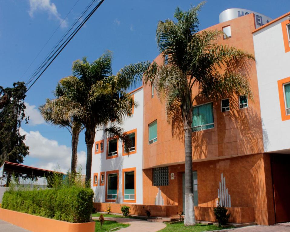a building with palm trees in front of it at Plaza Fontesanta in Amecameca de Ju&aacute;rez
