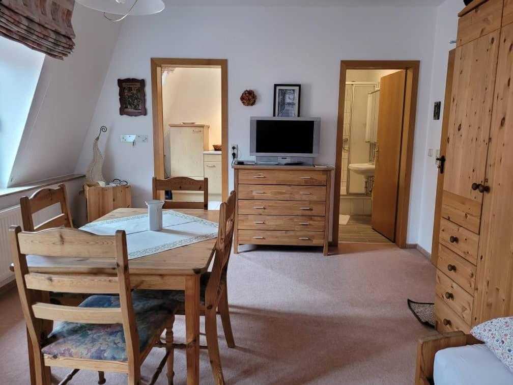 a living room with a dining table and a television at Jena Paradies in Jena