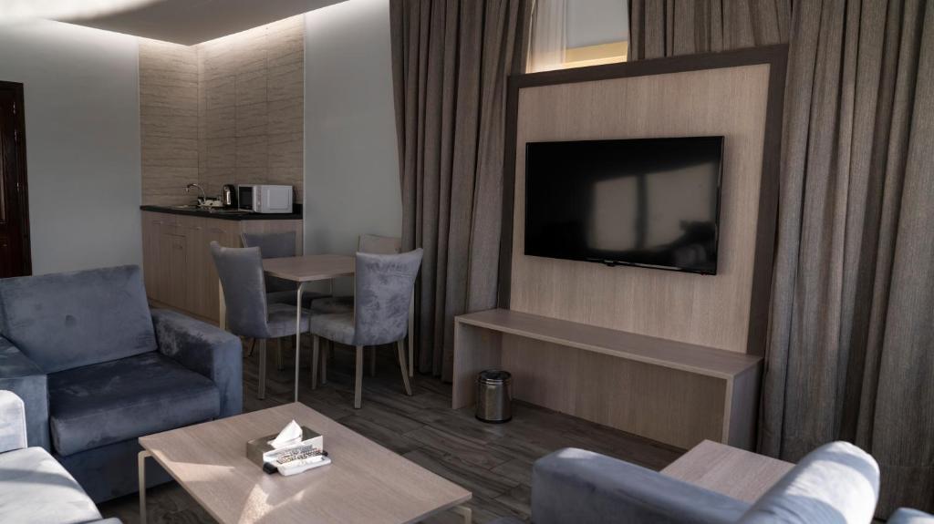 a living room with a tv and a couch and a table at Seven Garden Palace in Taif