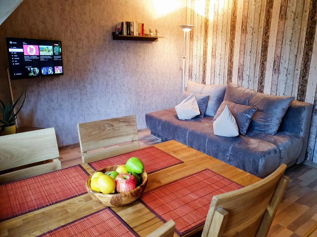 sala de estar con sofá y mesa con un bol de fruta en Ferienwohnung direkt am Ski und Rodelhang, en Kurort Oberwiesenthal