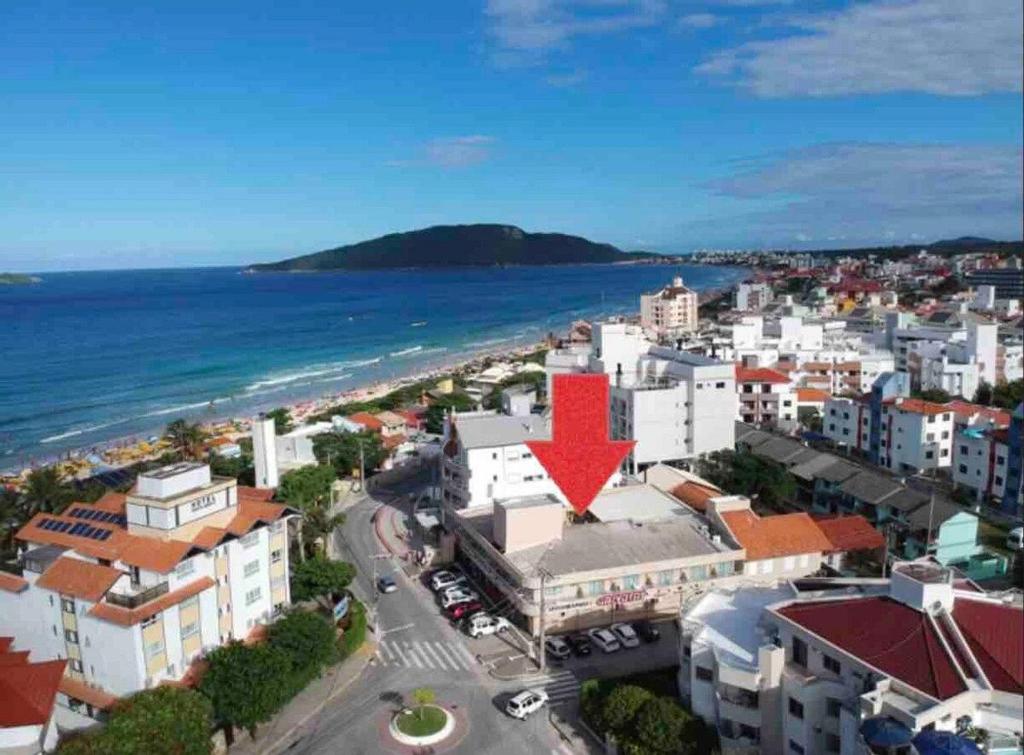 Eine Stadt mit einem roten Pfeil auf einem Gebäude in der Unterkunft Residencial Gaivotas 09 - 1 Quartos - 30m praia Wifi Cadeira e guarda sol in Florianópolis
