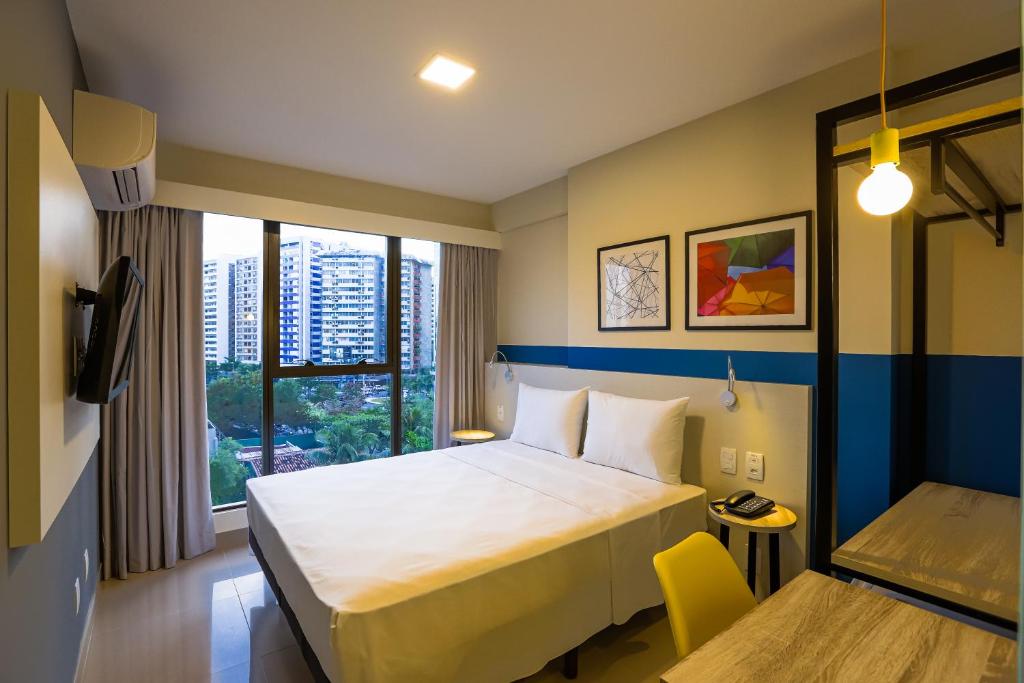 a hotel room with a bed and a window at Transamerica Fit Recife in Recife