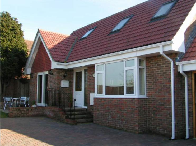 a brick house with a red roof at Bramley Cottage in Sandown