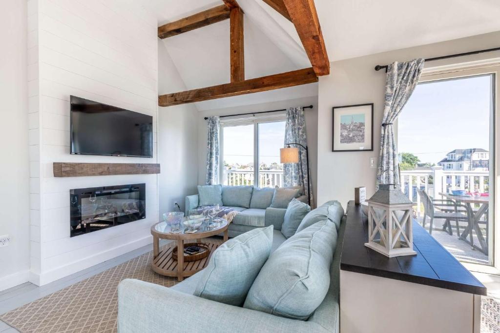 a living room with a blue couch and a fireplace at Sea Love Beach House in Newburyport