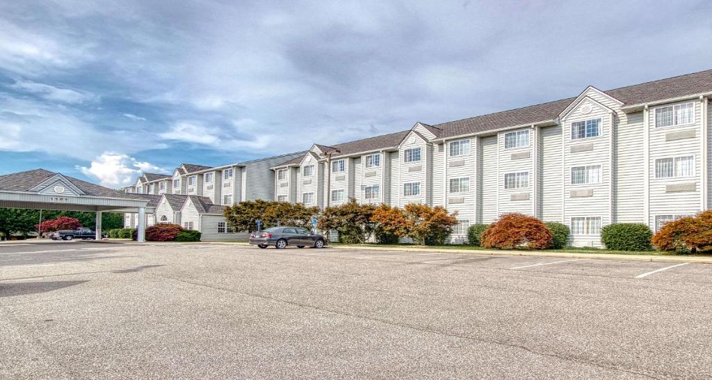 a large building with a car parked in a parking lot at SureStay Hotel by Best Western Christiansburg Blacksburg in Christiansburg