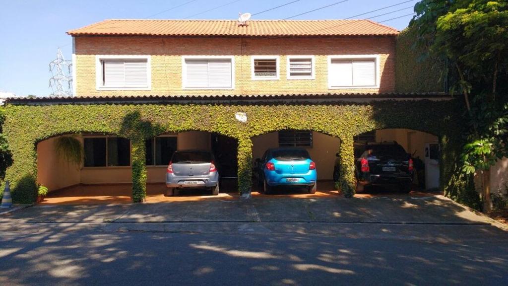 uma casa com dois carros estacionados numa garagem em Flat Tacaunas em São Paulo