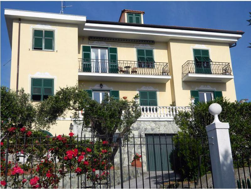 un bâtiment avec une clôture et des fleurs devant lui dans l'établissement Art&Kitchen, à Savone