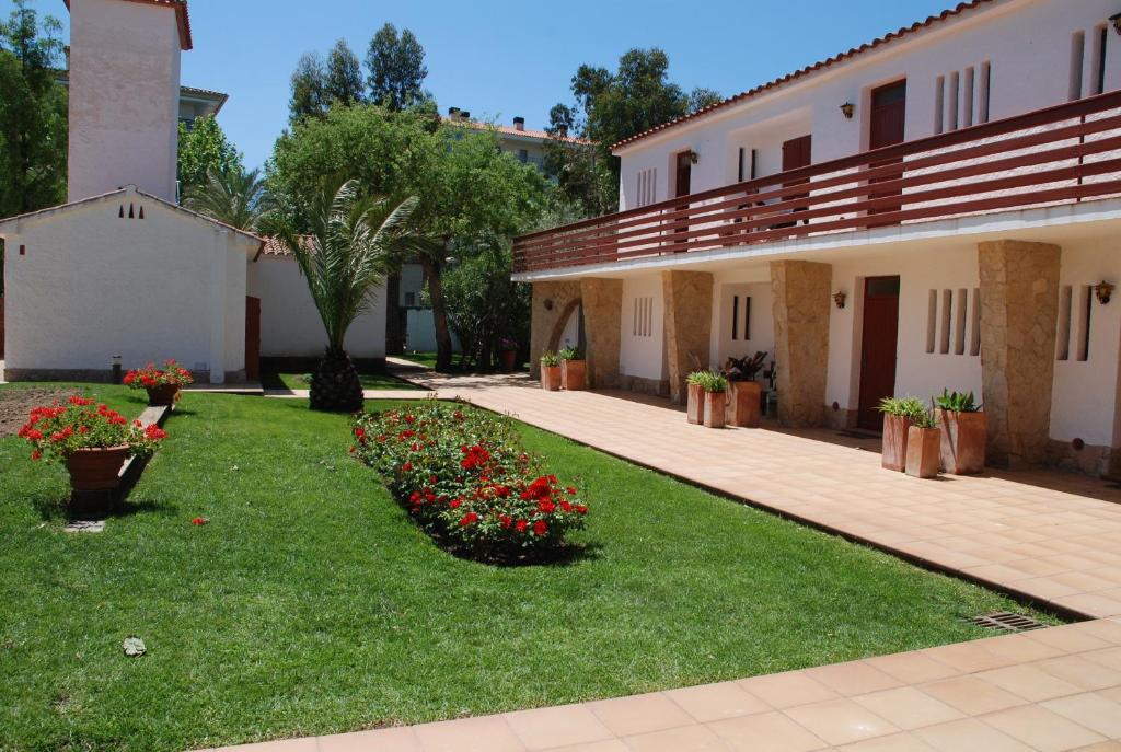 a courtyard of a building with flowers in the grass at Apartaments Margarita Sabina Pinell in Platja d'Aro