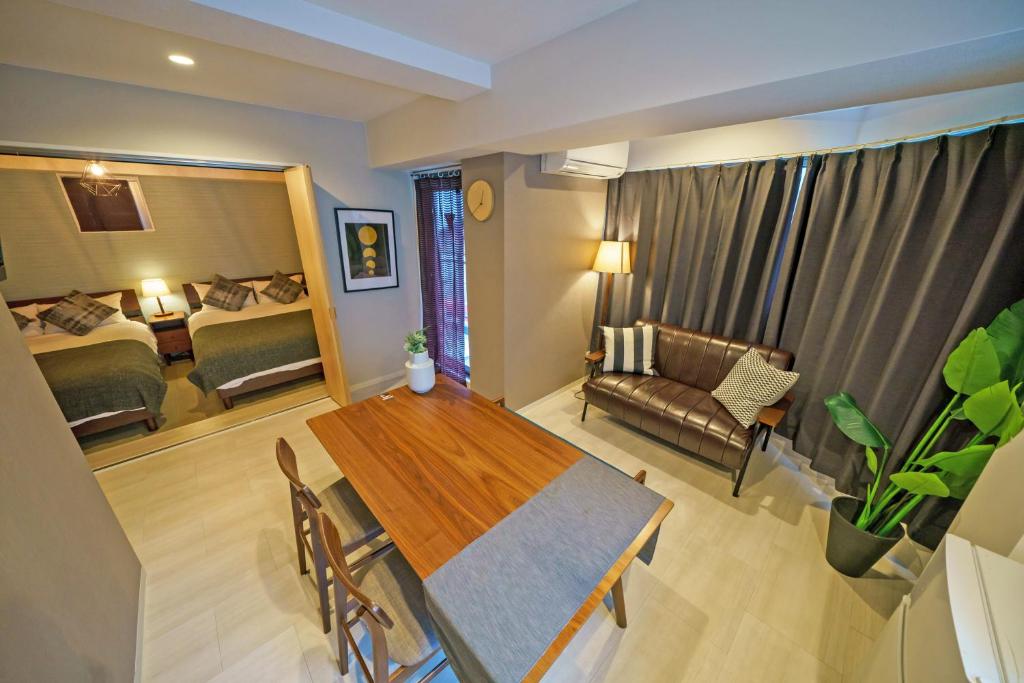 ein Wohnzimmer mit einem Esstisch und ein Schlafzimmer in der Unterkunft Gracia Hotel in Osaka