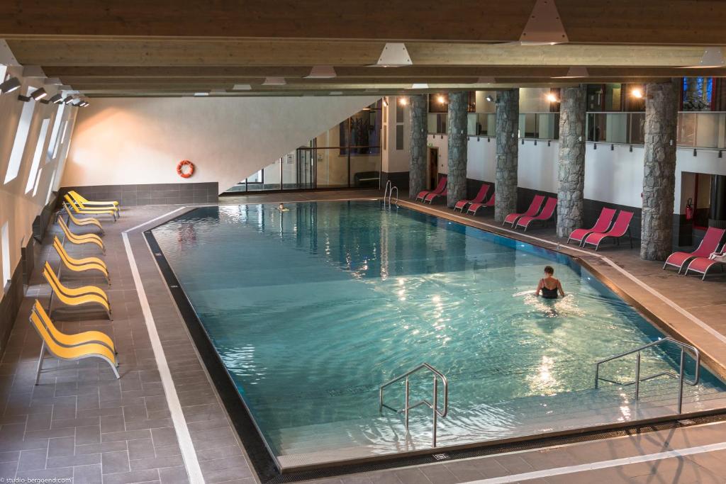 a person swimming in a large swimming pool at CGH Résidences & Spas Le Centaure in Flaine