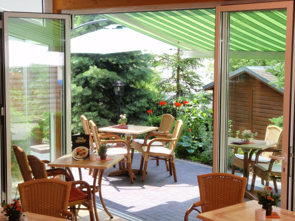 a patio with tables and chairs and sliding glass doors at Hotel Arcus in Elsterwerda