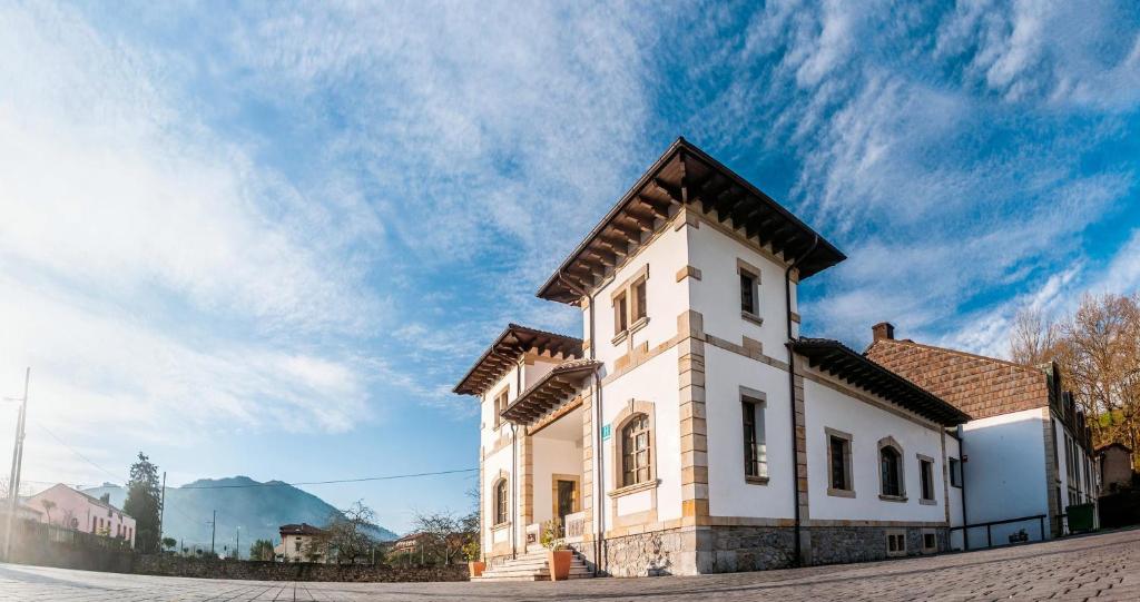 a white building with a roof on a street at Hotel Granda in Cangas de Onís