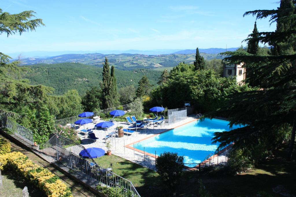 - une piscine avec parasols dans l'établissement Villa Sant’Uberto Country Inn, à Radda in Chianti
