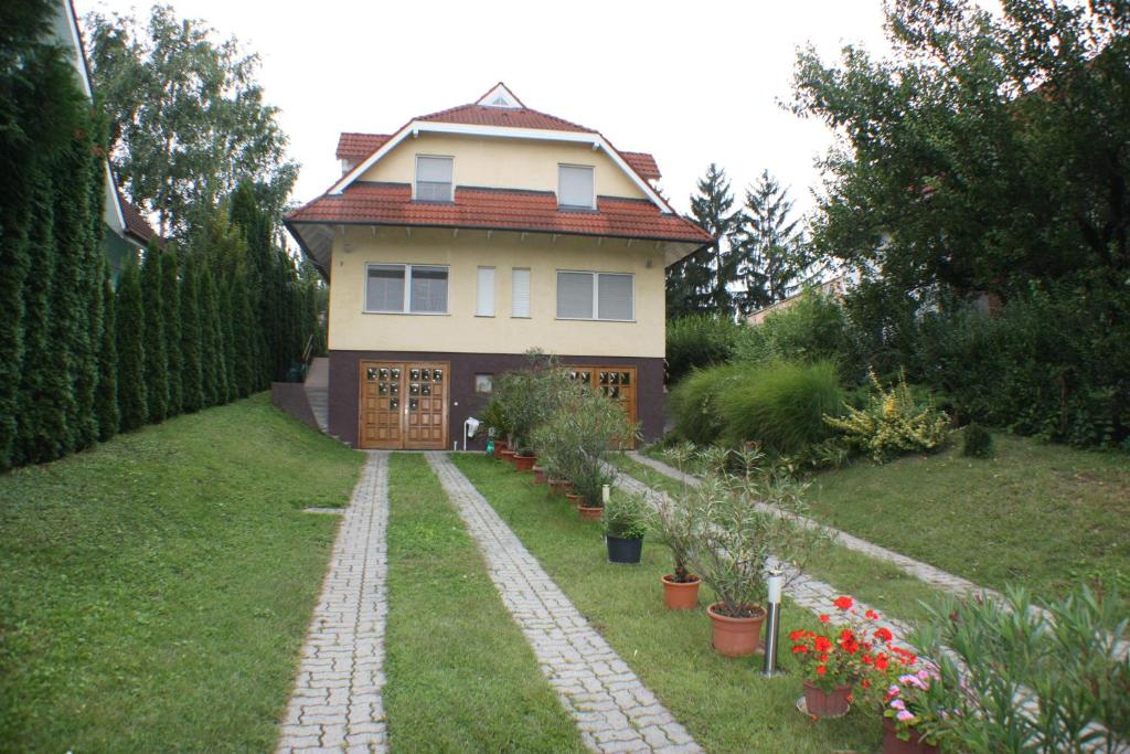 una casa con una pasarela delante de ella en Roni Ház, en Siófok