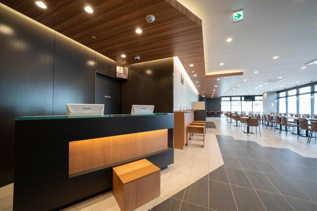 a restaurant with a bar with tables and chairs at Washington R&B Hotel Nagoya Shinkansenguchi in Nagoya