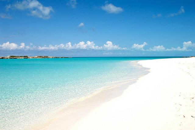 una spiaggia bianca con acqua blu e cielo di Tropical View Villas a Hartswell