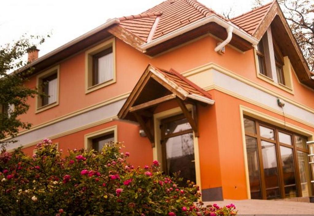 a orange house with a brown roof at Publo Étterem és Panzió in Csákvár