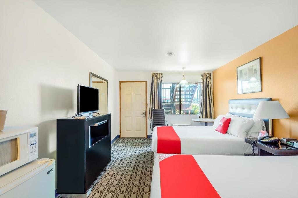 ein Hotelzimmer mit einem Bett und einem Flachbild-TV in der Unterkunft Arlington Motor Inn in Arlington
