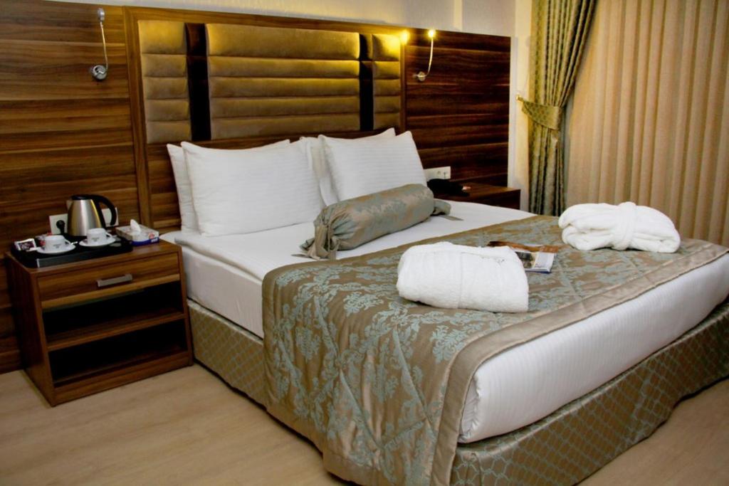 Una habitación de hotel con una cama con dos toallas. en Adanava Hotel en Adana